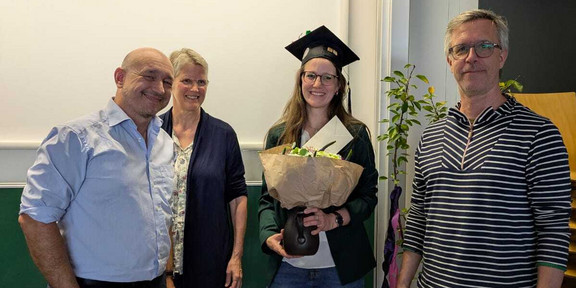 Gruppenfoto. Marcel Feichtinger, Angelika Prass, Leevke Wilkens mit Doktorhut und Blumenstrauß in der Hand, Riclef Schomerus