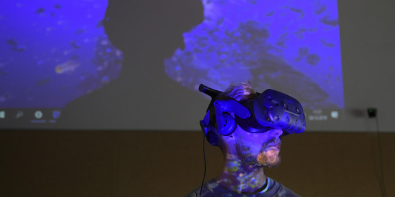 Mann mit VR-Headset vor blau angestrahltem Hintergrund