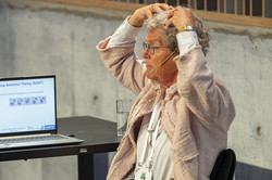 Foto. Mijna Hadders-Algra. Neben sich einen Laptop mit der Folie "Group Selction Theory (NGST)"